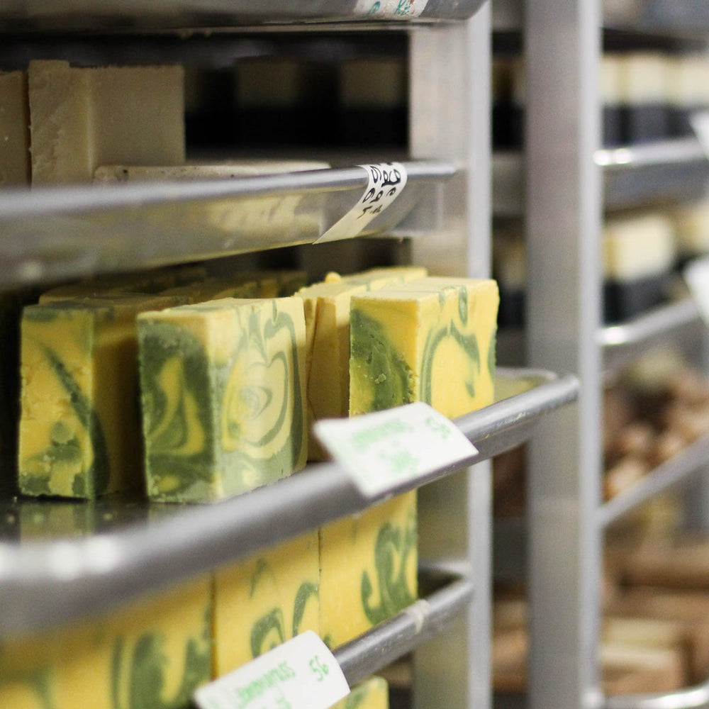 from an angle silver soap rack displaying yellow and green swirled lemongrass sage soap 