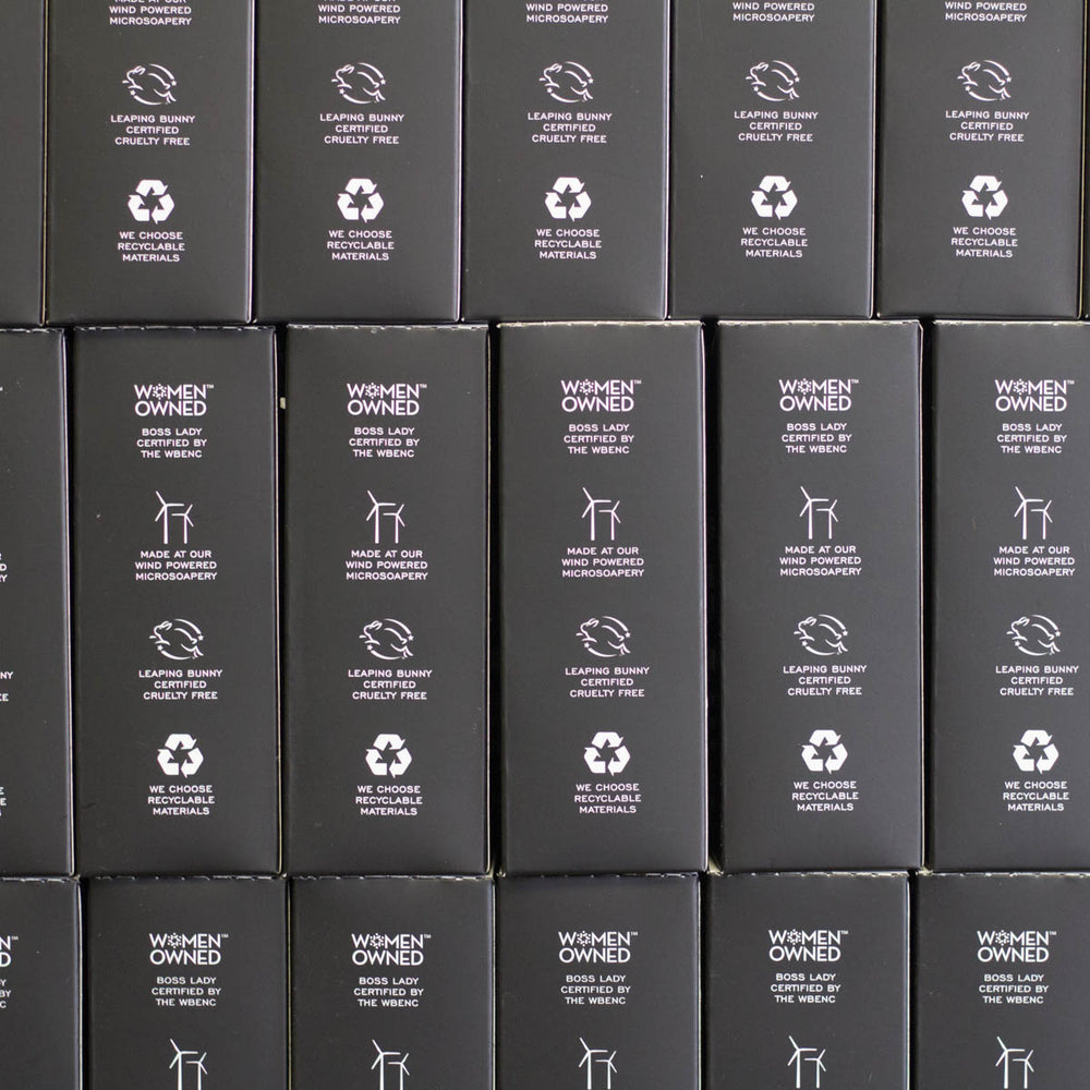 Stacked black boxes that say Women owned boss lady certified by the wbenc, Made at our wind powered microsoapery, Leaping bunny certified cruelty free, We choose recyclable materials.
