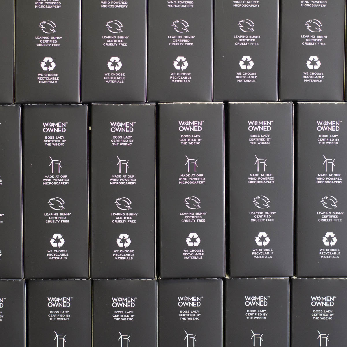 Stacked black boxes that say Women owned boss lady certified by the wbenc, Made at our wind powered microsoapery, Leaping bunny certified cruelty free, We choose recyclable materials.